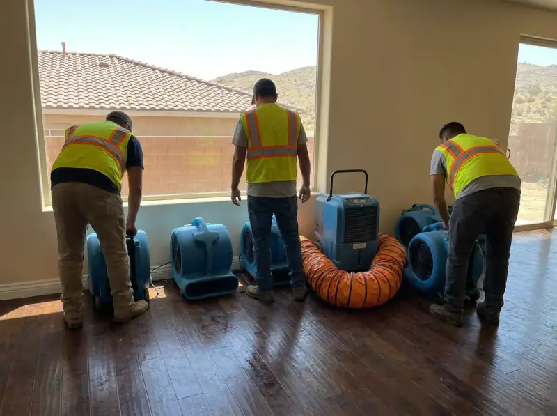 Commercial air movers and an LGR dehumidifier running on a wet floor in Victorville, California